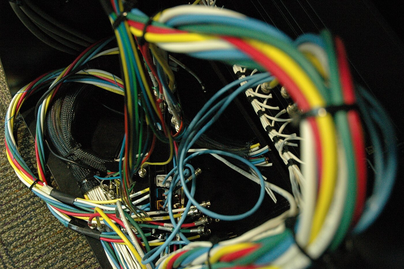 Network switch cabling and patch leads inside a Microsoft facility in Redmond, illustrating the DHCP, gateway and policy server infrastructure affected by the October 2026 wormable flaws