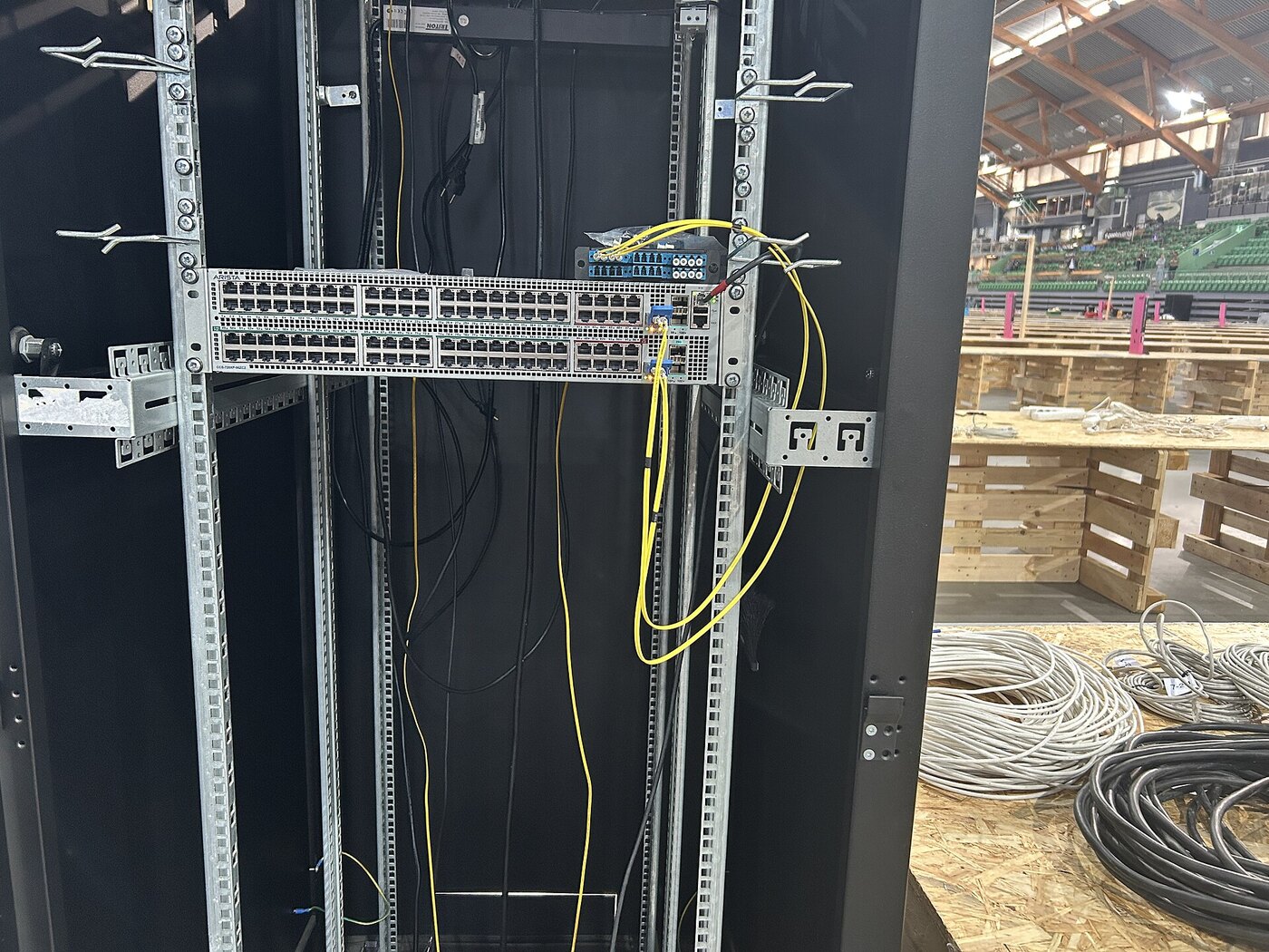 An Arista network switch mounted in a distribution rack with fibre and copper patching, the class of branch server infrastructure managed by a VeloCloud Orchestrator affected by this enterprise IT news zero-day