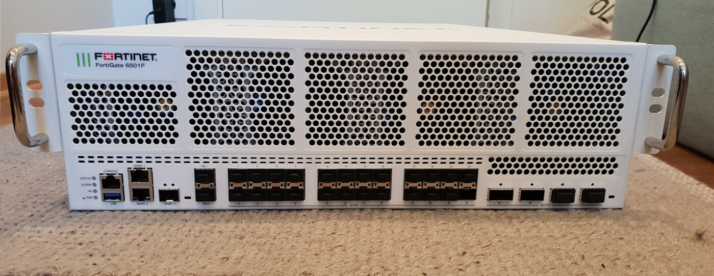 A rack-mounted Fortinet FortiGate 6501F firewall chassis showing management, console and SFP ports, the class of edge server infrastructure targeted for credential theft in the k0t campaign